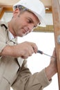 male worker using screwdriver while fitting door Royalty Free Stock Photo