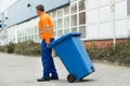 Male Worker Walking With Dustbin On Street Royalty Free Stock Photo