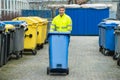 Male Worker Walking With Dustbin On Street