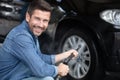 male worker washes car tyre