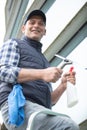 male worker washing window glass from outside