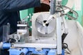 A male worker works on a larger metal iron locksmith lathe, equipment for repairs, metal work in a workshop at a metallurgical