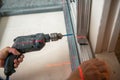 Male worker works with profile for drywall, setting, assembling with drill. Construction work, repair. Royalty Free Stock Photo