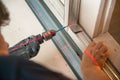 Male worker works with profile for drywall, setting, assembling with drill. Construction work, repair Royalty Free Stock Photo