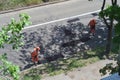 male workers clean the road after repairing it