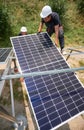 Male workers installing solar panels on sunny day. Royalty Free Stock Photo