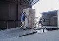 Truck loading and shipping. Male workers are loading the goods in cardboard boxes on a truck.