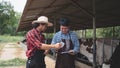 Male workers pay money and shake hands with farmers on the dairy farm.Agriculture industry, farming and animal husbandry concept , Royalty Free Stock Photo