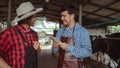 Male workers pay money and shake hands with farmers on the dairy farm.Agriculture industry, farming and animal husbandry concept , Royalty Free Stock Photo