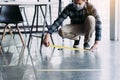 Male workers preparing masking tape to symbolize social distances