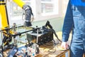 A male working electrician in a robe professionally works on a table for repair in a workshop for remoting electronics and Royalty Free Stock Photo
