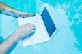 Male works on minicomputer under water. Minicomputer at the bottom of the pool. The concept of a lot of work at work Royalty Free Stock Photo