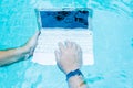 Male works on minicomputer under water. Minicomputer at the bottom of the pool. The concept of a lot of work at work Royalty Free Stock Photo