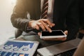 Male writes information businessman working on tablet and laptop computer writing business plan while sitting in office