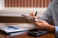 Male writes information businessman working on tablet writing business plan while sitting in cafe in the morning