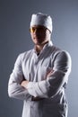 Male young doctor in cap and yellow glasses in contrasting light