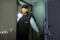 Security Guard Searching With Flashlight In Room Royalty Free Stock Photo