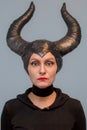 Maleficent - beautiful woman from a fairytale with hair horns and creative make-up for the Halloween party