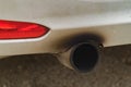 A malfunctioning engine and exhaust afterburner system show the results close up in the form of black soot over the muffler of an