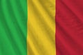 Mali flag with big folds waving close up under the studio light indoors. The official symbols and colors in banner