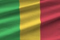 Mali flag with big folds waving close up under the studio light indoors. The official symbols and colors in banner