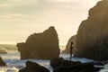 Malibu, California, USA - JULY 06, 2018, a girl stands on a stone cliff on El Matador Beach at sunset on a clear sunny