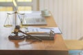 The mallet and brass scales are placed on the table in the lawyer`s office for decorative purposes and are a symbol of justice in