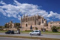 Cars moving on road by gothic La Seu Cathedral in city against sky