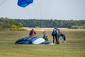 A fine day during vacation time. Many practices their favorite sport. Picture of a skydiver landing after a skydive