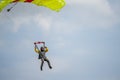 A fine day during vacation time. Many practices their favorite sport. Picture of a skydiver landing after a skydive