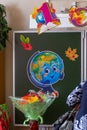 Classroom decorated for September 1st: drawing of a globe on a chalkboard and a bouquet of flowers, blur effect.