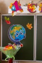 Classroom decorated for September 1st: drawing of a globe on a chalkboard and a bouquet of flowers, blur effect.