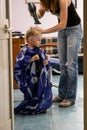 2010.06.12, Maloyaroslavets, Russia. Hairdresser dries little boy hair at salon.