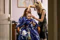 2010.06.12, Maloyaroslavets, Russia. Hairdresser dries little boy hair at salon.