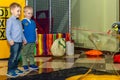 Two boys watch an animator makes a big soap bubble. Children`s birthday celebration in the gaming complex.