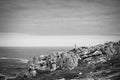 A girl walks along some rocks