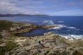 A girl walks along some rocks in Galicia Spain