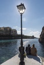 Sun Worship and lamp post on the jetty in Xlendi Royalty Free Stock Photo