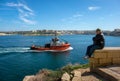 Malta, Valletta - March 2020. Morning in the capital of Valletta. Red boat and a man watching the sea