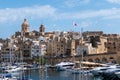 Malta, The view of Birgu with Our Lady of Annunciation church, big dome over the Dockyard bay with moored yacht.