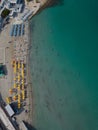 Malta yellow and blue lines of sunshades on a sandy beach next to clear turquoise sea aerial top down Royalty Free Stock Photo