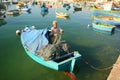 Fisherman in boat tending his nets