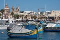 Maltese fishing village of Marsaxlokk with traditional painted boats in Foreground