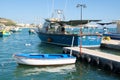 Marsaxlokk, Malta, August 2019. Traditional vintage fishing boats at the pier in the early morning.