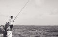 Teenager boy fishing in the sea with other fishermen Royalty Free Stock Photo