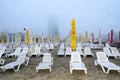 Beach of Black Sea from Mamaia, Romania with sunbeds and umbrellas, foggy day. Royalty Free Stock Photo