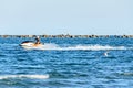 Man riding a jet ski over blue Black Sea water, banana boat. Royalty Free Stock Photo