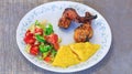 Mamaliga or polenta, baked chicken legs and salad in fancy plate. Traditional food and culinary culture specific for Balkan Royalty Free Stock Photo