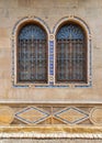 mamluk style two Arched Windows with Wrought Iron Grilles in a brick wall