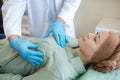 Mammologist in blue protective gloves palping breast of his patient